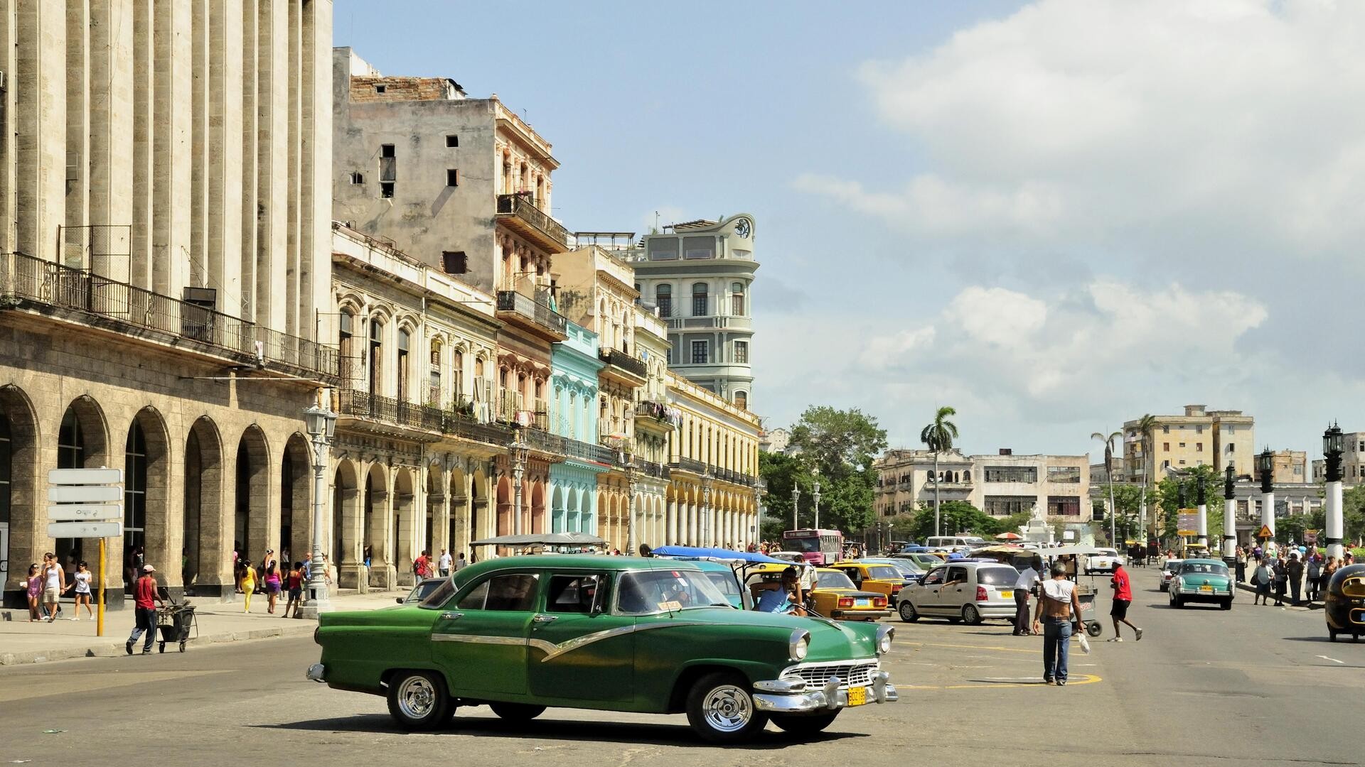 Винтажный автомобиль на фоне зданий с красочными фасадами, Старая Гавана.
